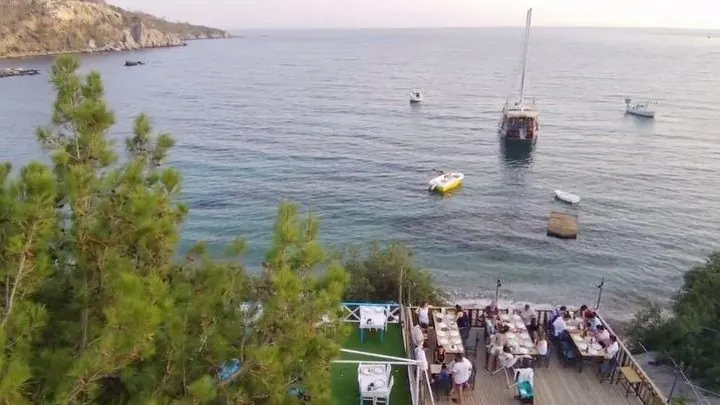 Akşam ışıklarıyla aydınlanan deniz kenarındaki restoran